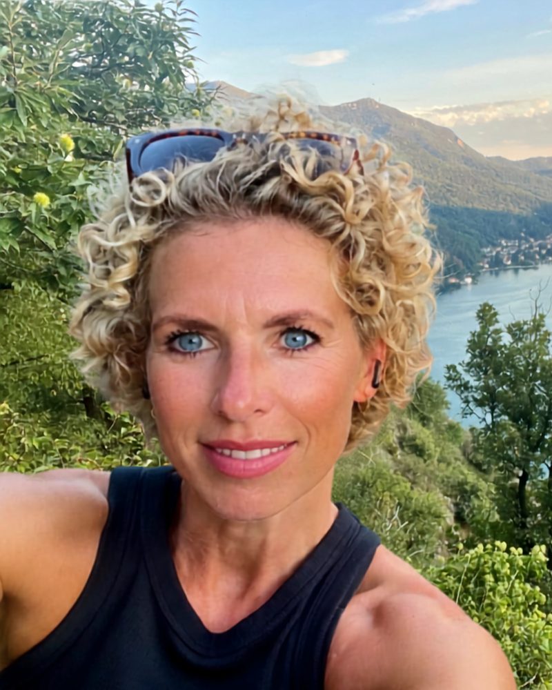 Julchen Mohr heute, mit Locken vor einem See in den Bergen